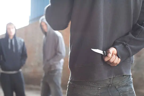 Photo of Two men being confronted by man with knife