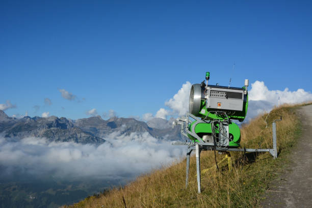 un cañón para hacer nieve en las montañas se encuentra en una pendiente en el verano y espera el invierno - mountain winter season machine snow making machine fotografías e imágenes de stock