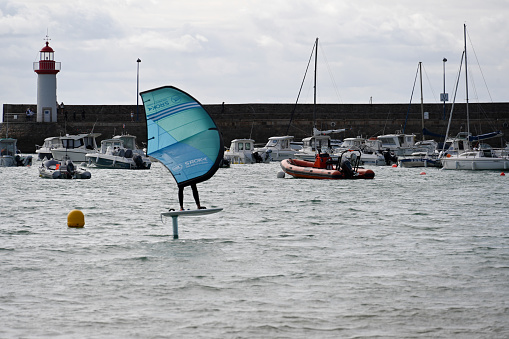 Erquy, Brittany, France, August 27, 2023 - A young athlete on a wing foil board in the harbor area of Erquy, Brittany.