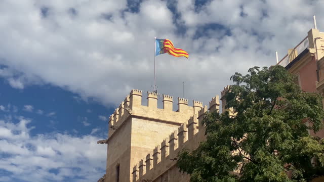 Valencian flag waving on top of the Silk Exchange building, Spain