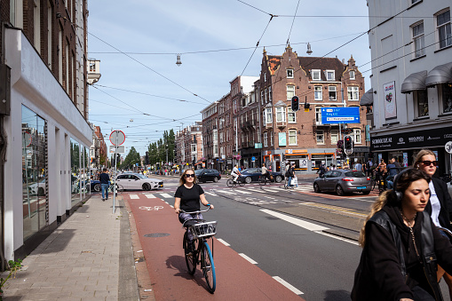 Amsterdam, Netherlands - September 3, 2023: Cyclists ride in a bike lane in central Amsterdam.