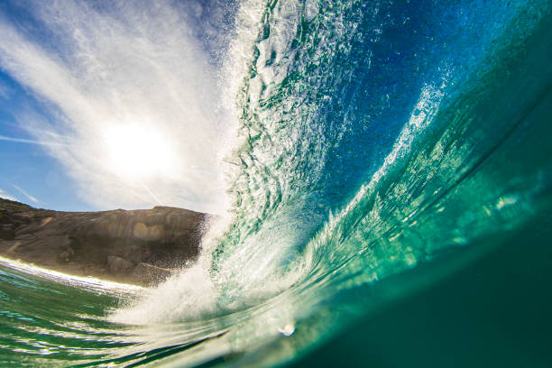 istock Close up of blue wave breaking at the beach on a sunny day 1697309332