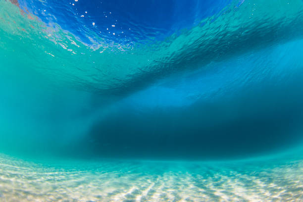 istock Underwater view beneath a wave forming over sand in crystal clear water 1697309350