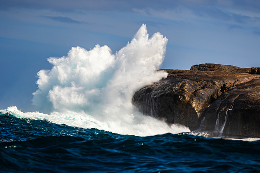 Powerful explosion of whitewash as giant wave breaks against cliff face in the open Atlantic Ocean. Photographed off the coast of South Western Australia.