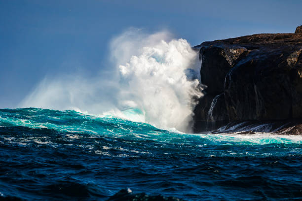 Breaking wave in rocky coastline. Splashing droplets. Barreiros, A Mariña area, Lugo province, Galicia, Spain.