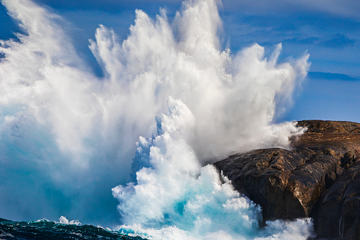 waves break in rolls against the light