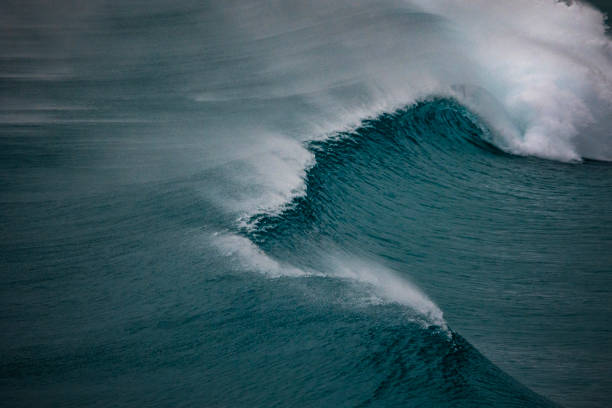 istock Smooth blue ocean swell waves breaking on the beach 1697312581