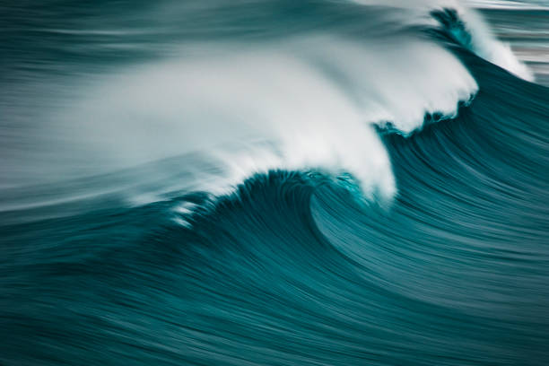 Curling blue ocean wave captured with motion blur stock photo