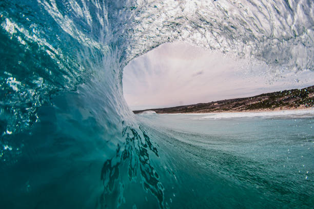 istock Looking out of smooth teal ocean swell wave curling over 1697313771