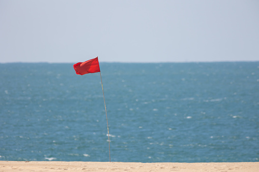 Red Flag on Beach Marking unsafe Water for Swimming