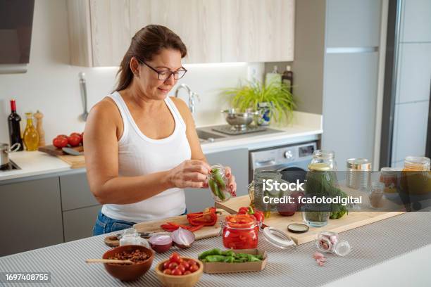 Woman Pickles And Cans Vegetables In Glass Jars Stock Photo - Download Image Now - Pickled, Vegetable, Fermenting