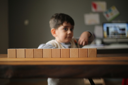 Little boy stacking wooden cubes