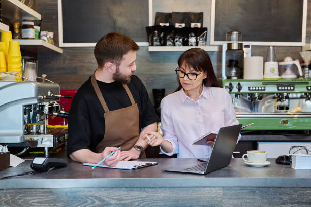 istock Team male and woman talking, working, using laptop, coffee shop 1697465188