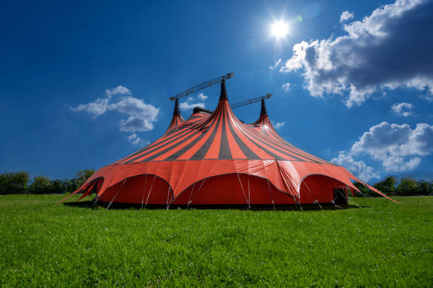 istock Red and black circus tent in green meadow 1697508579