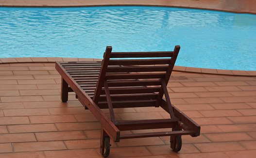 a small decorative deck chair at a swimming pool