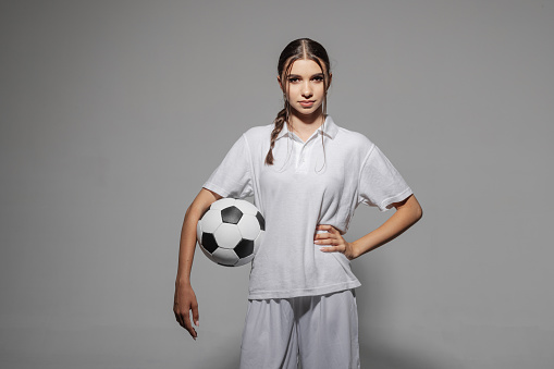 girl soccer player in white uniform on an empty white background, women's football