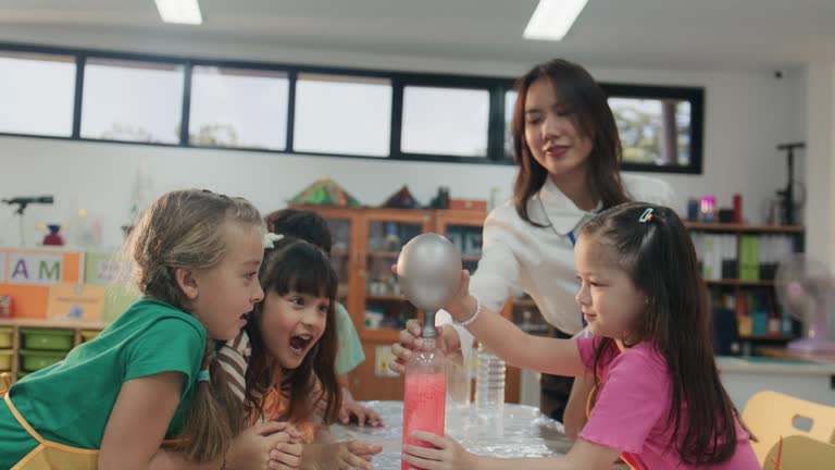 Group of happy students excited about science experiment in classroom at school