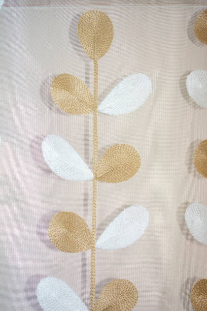 istock Embroidered twig on mesh tulle. Twig with white and brown flowers. 1697546129