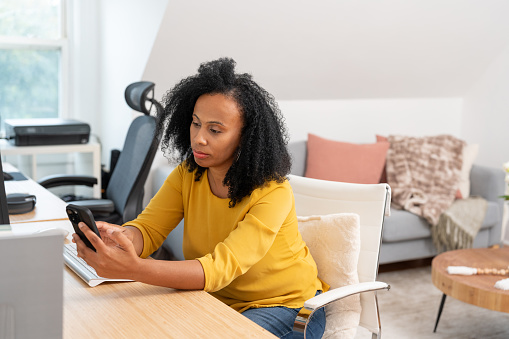 Black woman working from home using computer with a concerned expression