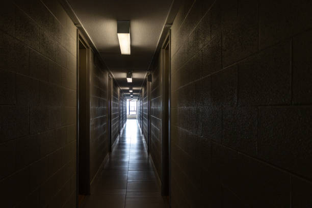 istock Dark and narrow hallway with industrial texture and single light source - window at the end with natural light 1697620870