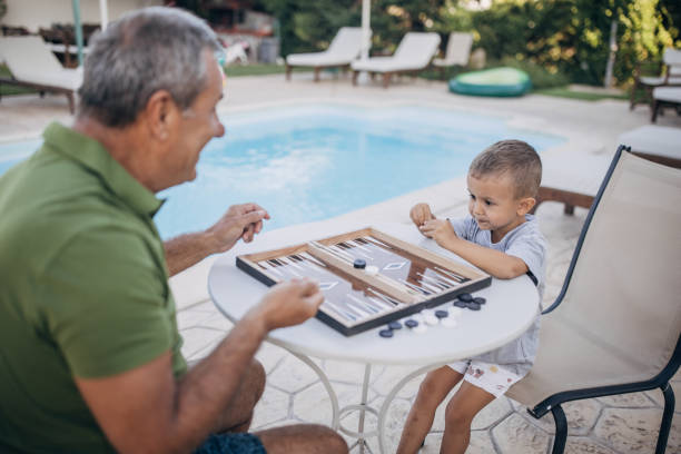 istock Grandfather and grandson play backgammon 1697631973