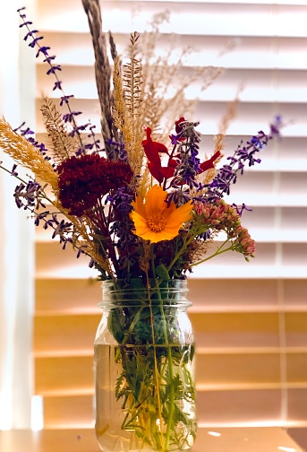 Still photo of rustic wildflower bouquet in mason jar