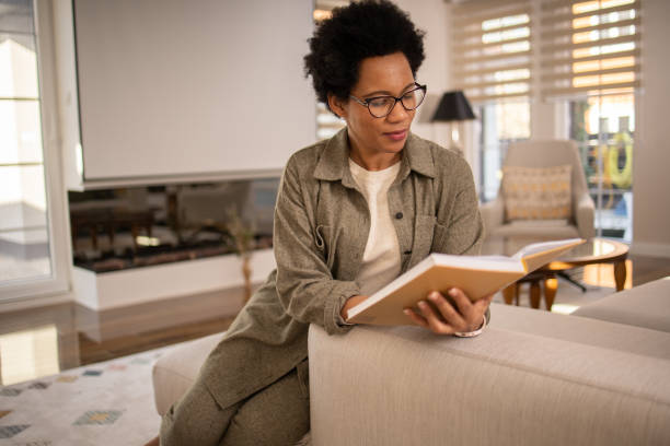 istock Woman reading book at home 1697802291