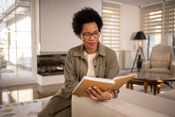 istock Woman reading book at home 1697802727