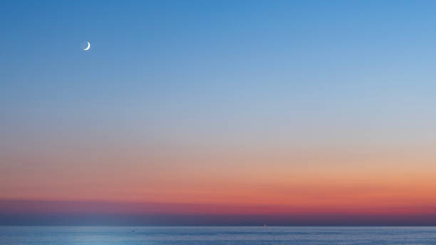 istock sunset with moon over the sea 1697803424