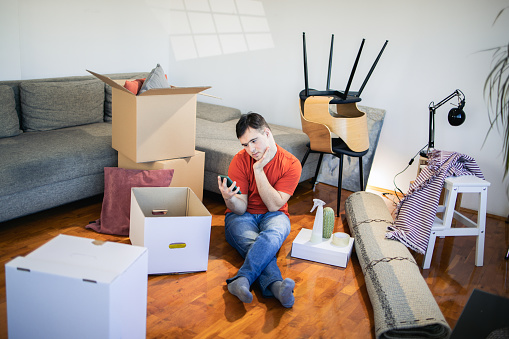 Portrait of a young man relaxing at home and using smartphone