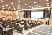 Seminar conference or town hall meeting blur background in auditorium or hotel room with audiences, speaker podium stage and presentation screen for entrepreneurship business speech or community talk