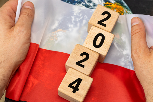 Polish flag held in hands with the date 2024, The concept of Poland's development, elections, and the political and economic situation in 2024
