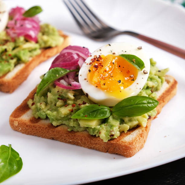 istock Healthy toast with mashed avocado, boiled eggs, spices and red onions. Delicious breakfast or snack. 1697879112