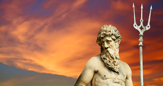 The mighty god of the sea and oceans Neptune (Poseidon). The ancient statue against dramatic view of sky.