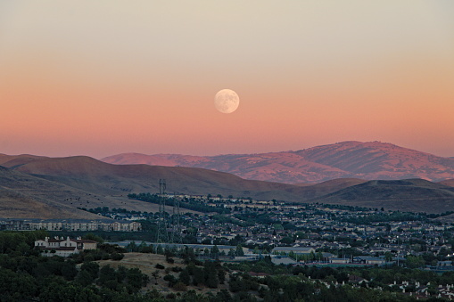 The Sturgeon moon was spotted rising as the last light of the sun illuminates the hills behind in a golden light