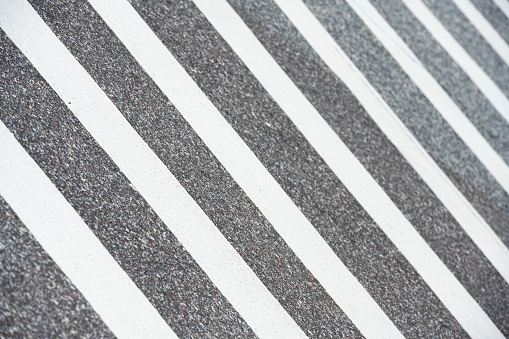 This is a background photograph of freshly painted white stripes marking a crosswalk on an asphalt road in Florida, USA.