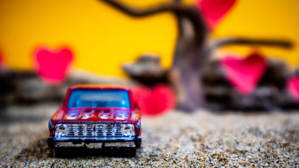istock Minahasa, Indonesia : December 2022, toy car with gradient orange background and a heart 1698028238
