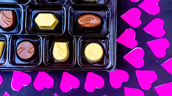 delicious chocolate surrounded by a pink heart on a black background