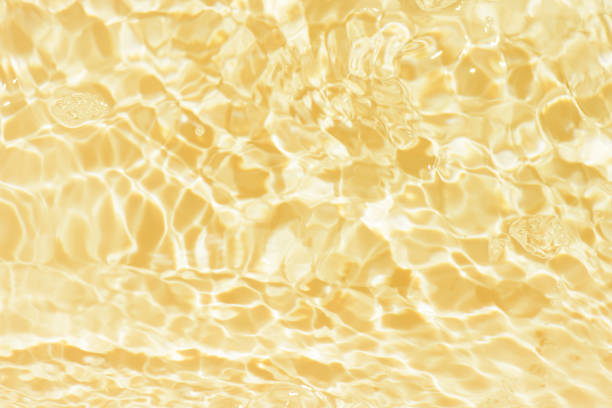 istock Defocus blurred transparent yellow colored clear calm water surface texture with splashes reflection. Trendy abstract nature background. Water waves in sunlight with copy space. Blue watercolor shining. 1698047588