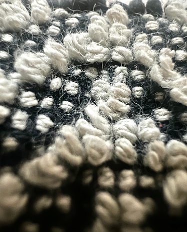 A macro photograph of the woven fabric of a sweater