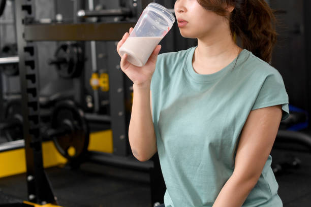 istock Young asian woman drinking protein drink at gym 1698123221