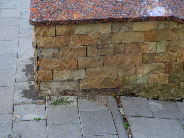 Sand stone wall surface, background of decorate. Stoneware cladding has fallen off the facade of the building. Brown wall of rough stone, background, texture.