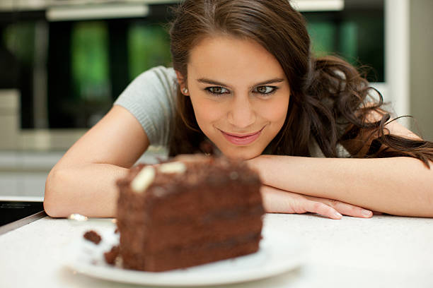 woman 見つめるにチョコレートケーキ - hungry ストックフォトと画像