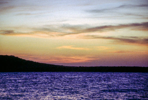 istock Sunsets and Sunrises over Water 1698203994