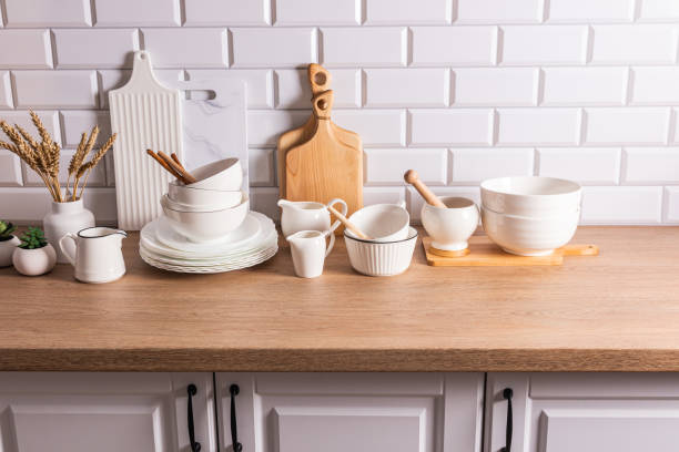 istock White ceramic utensils and kitchen utensils on a wooden countertop in an eco-friendly kitchen with green indoor plants. Cozy house. 1698211411