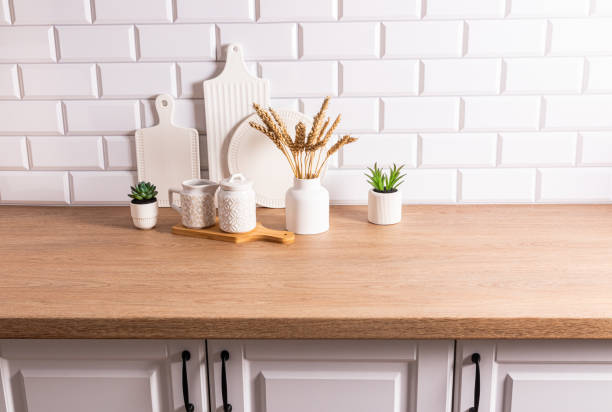 istock Beautiful kitchen background with different items and kitchen utensils made of eco-friendly materials. wooden countertop, white brick wall. 1698211442