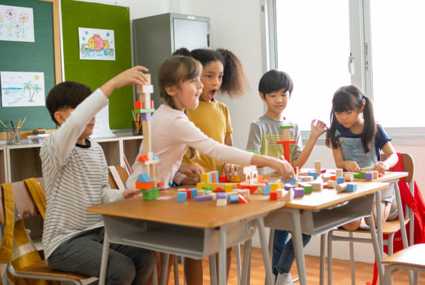 istock Happy diverse multiethnic kids Elementary school students group during take a break and play with colorful blocks in classroom. Excited kids having fun together teamwork and friendship concept. 1698211742