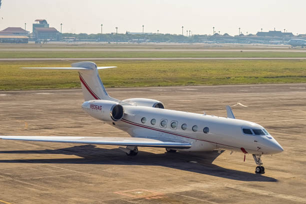частный самолет или gulfstream g600, припаркованный на перроне международного аэропорта джуанда с туманным небом во второй половине дня - falcon стоковые фото и изображения