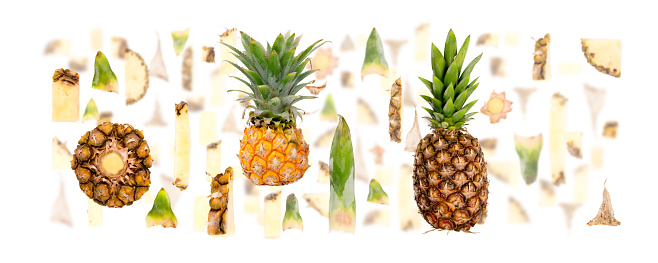 Abstract background made of Pineapple fruit pieces, slices and leaves isolated on white.