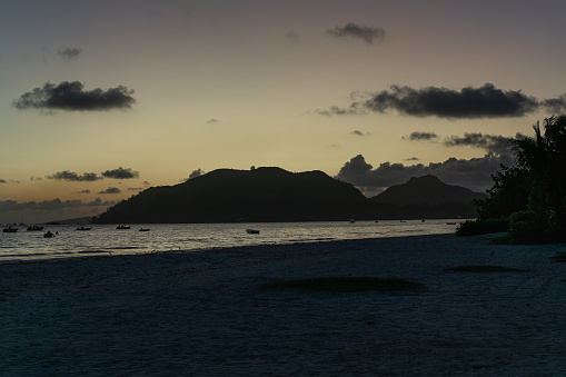 Sunrise behind the hills at the beach Anse Lazio of the Seychelles.